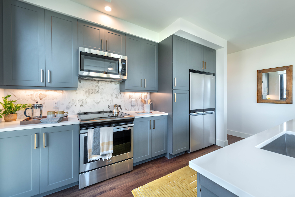 Modern kitchen with light gray cabinets at Aster