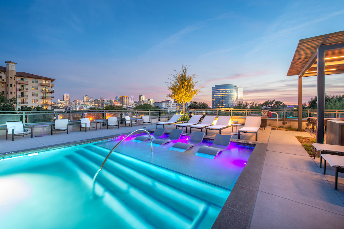 Pool and lounge chairs at Aster at dusk