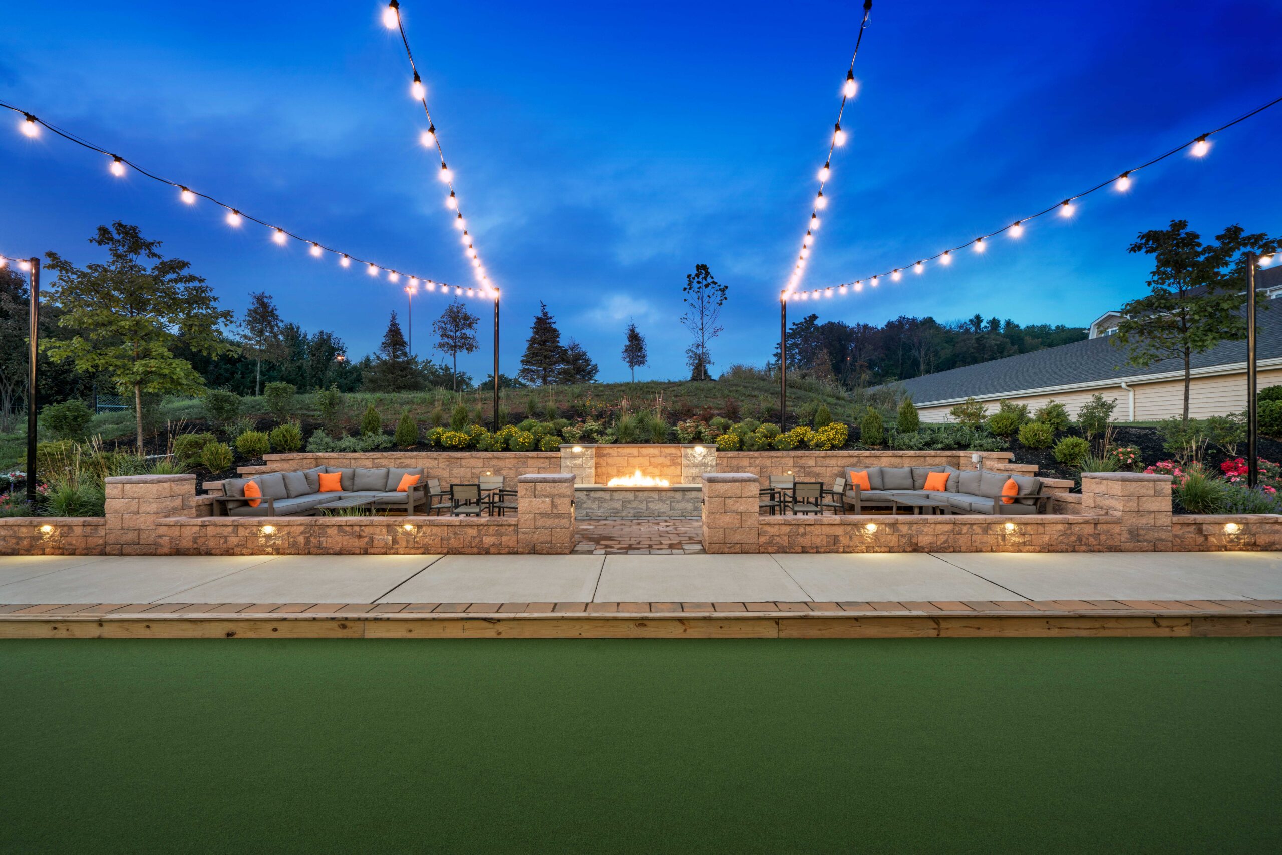 Fire pit with seating and bocce ball court outside of Parc Plymouth Meeting