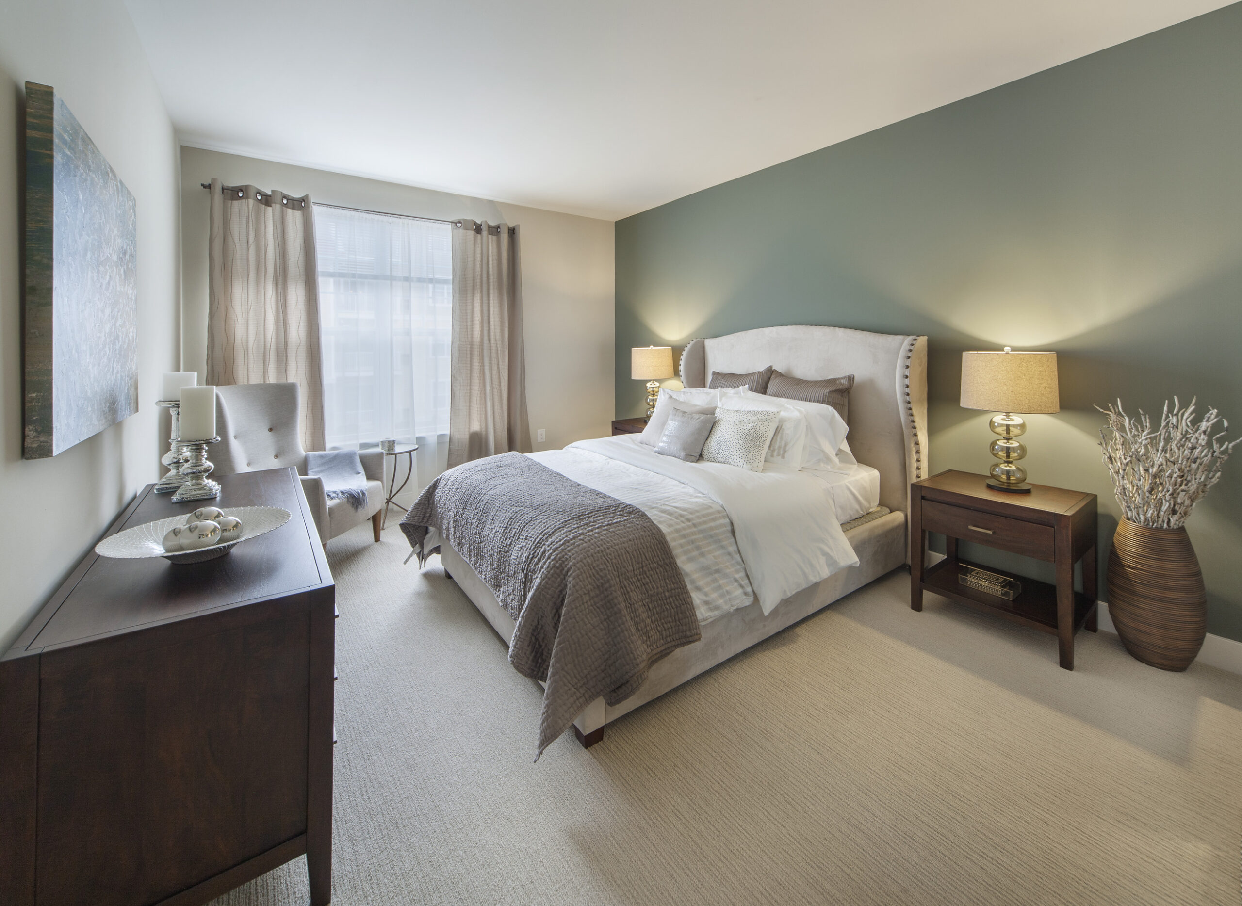 Model bedroom at Parc Plymouth Meeting with green accent wall and plush carpeting