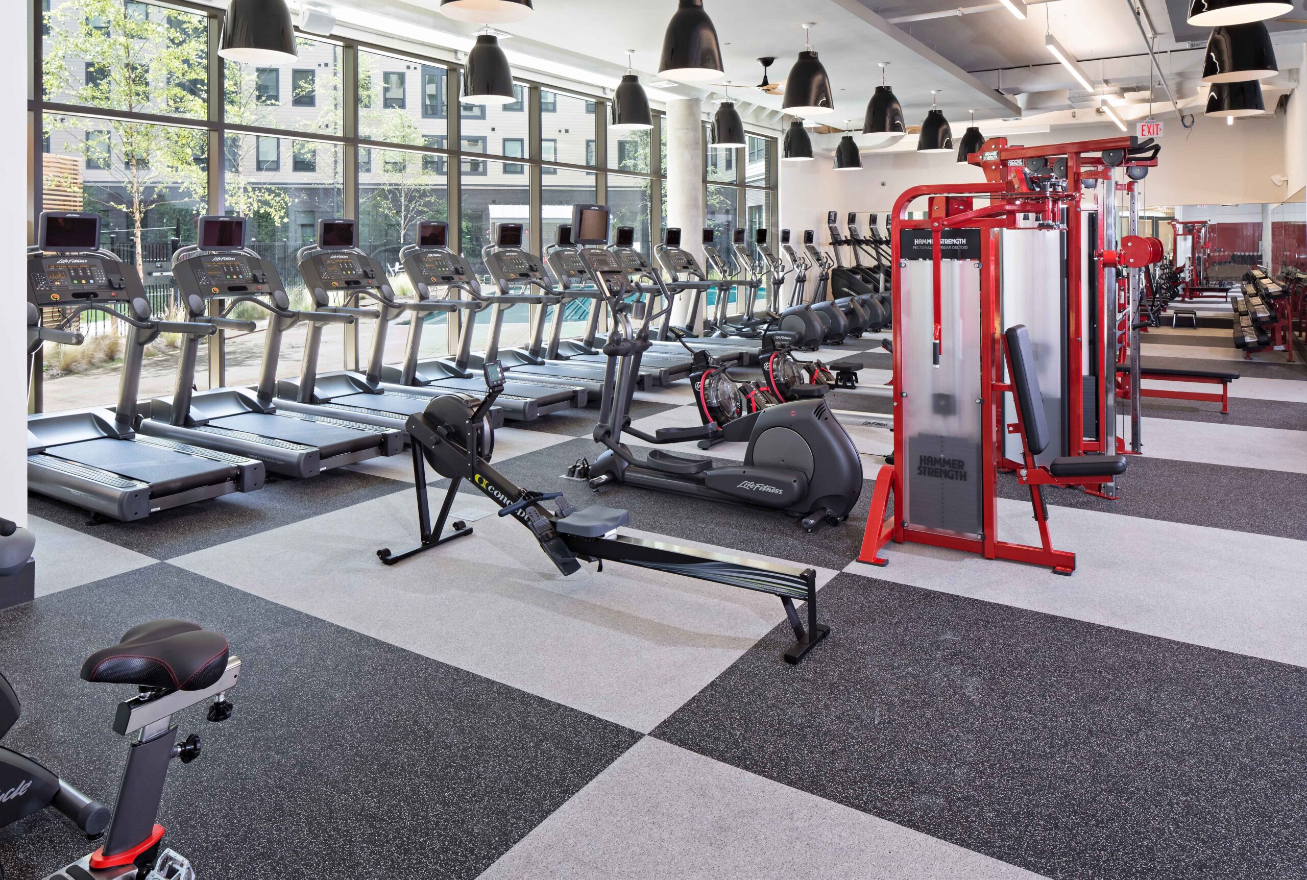 A row of treadmills by the windows and other equipment in the fitness center at Terrapin Row