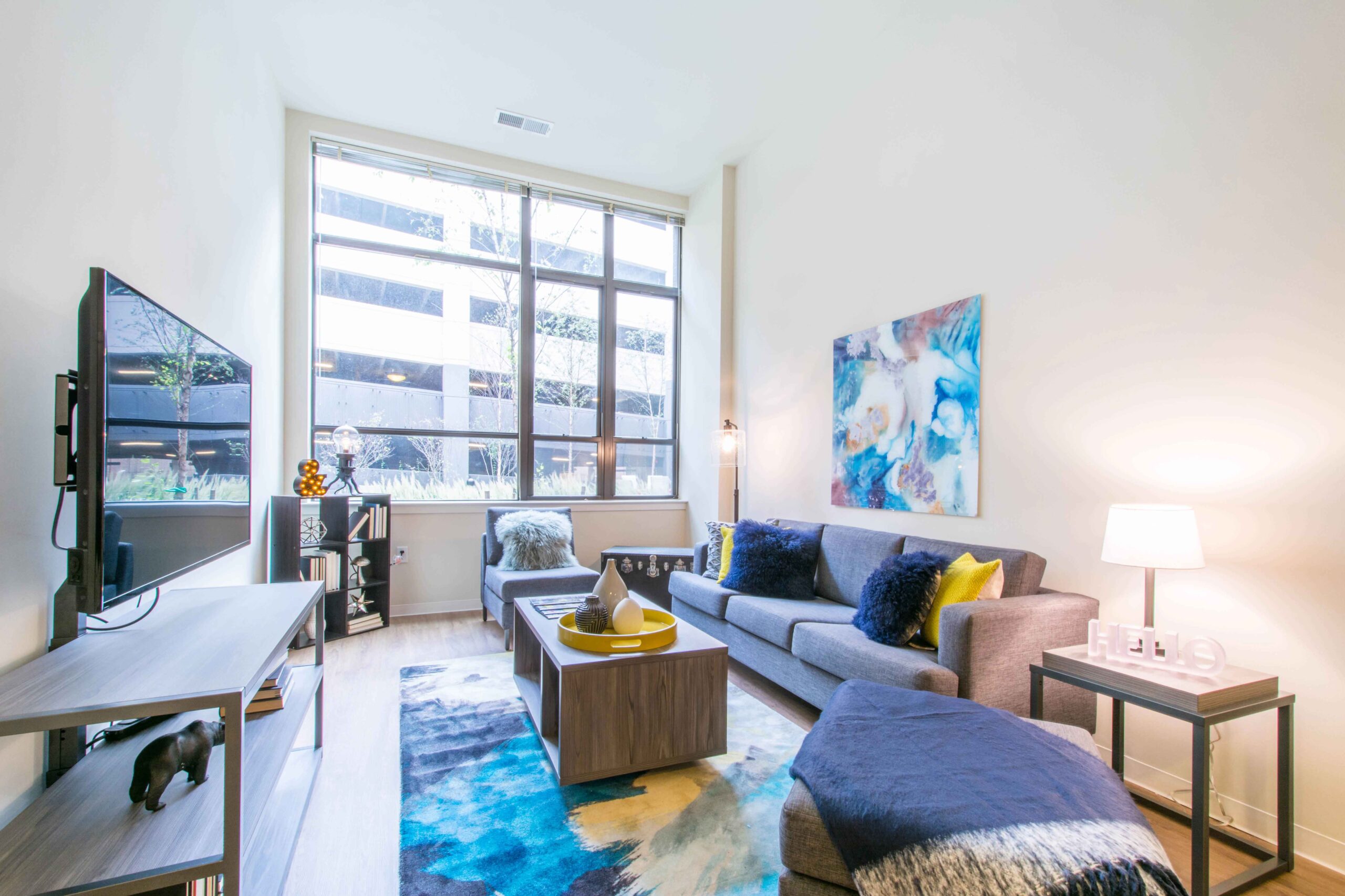 Model living room with large windows at Terrapin Row