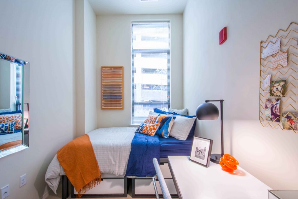 Model bedroom with bed, desk and bulletin board at Terrapin Row