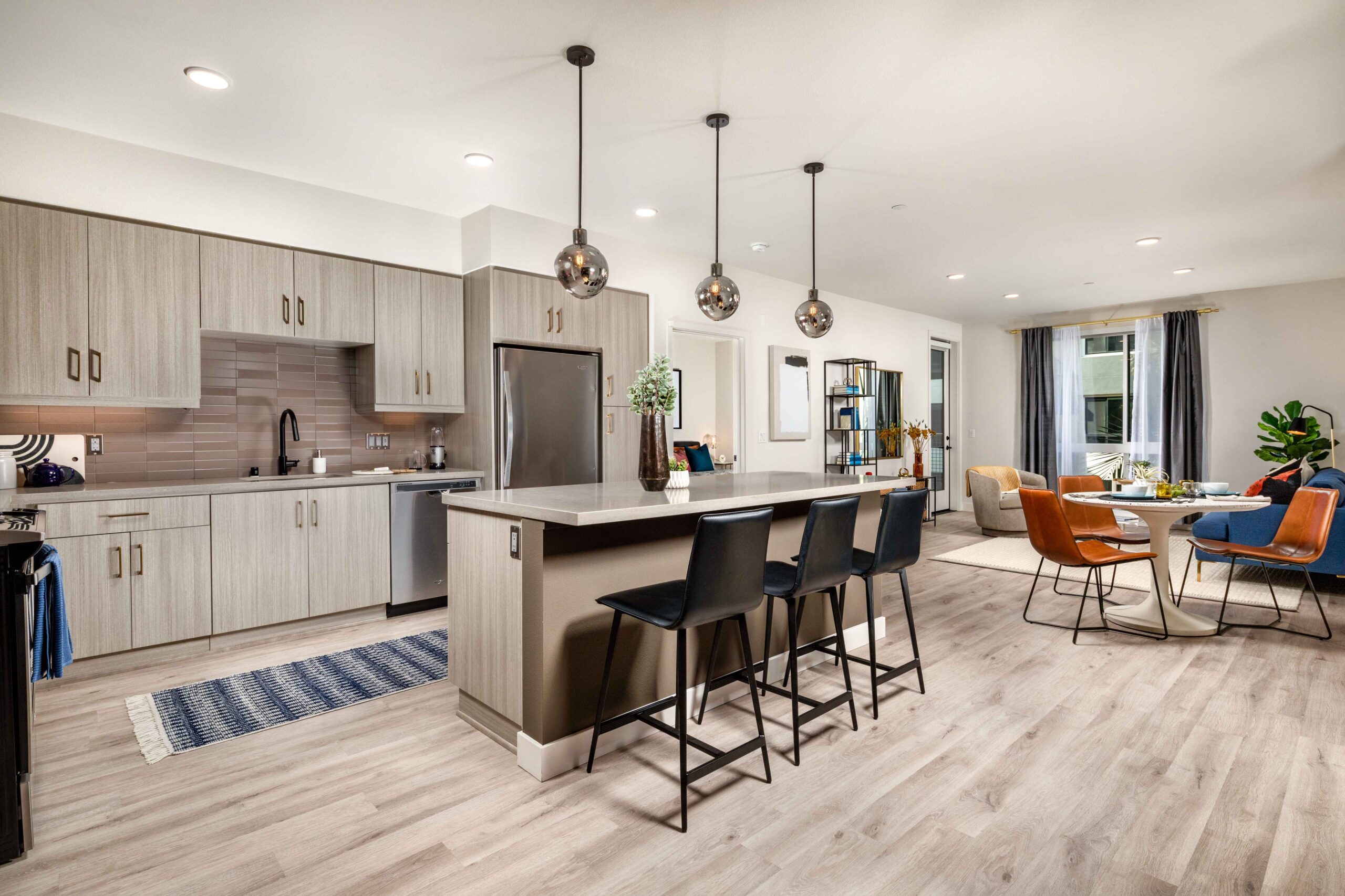 Modern kitchen with island seating and dining and living areas in background at Cameo
