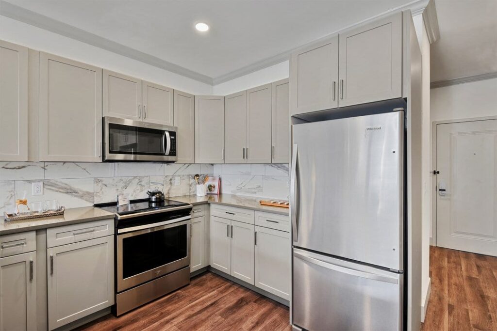 Modern kitchen with light gray cabinets and stainless steel appliances at Carraway
