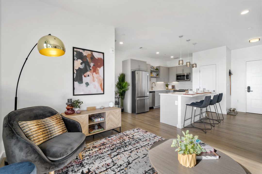 Living area and kitchen with island seating at Emblem 120