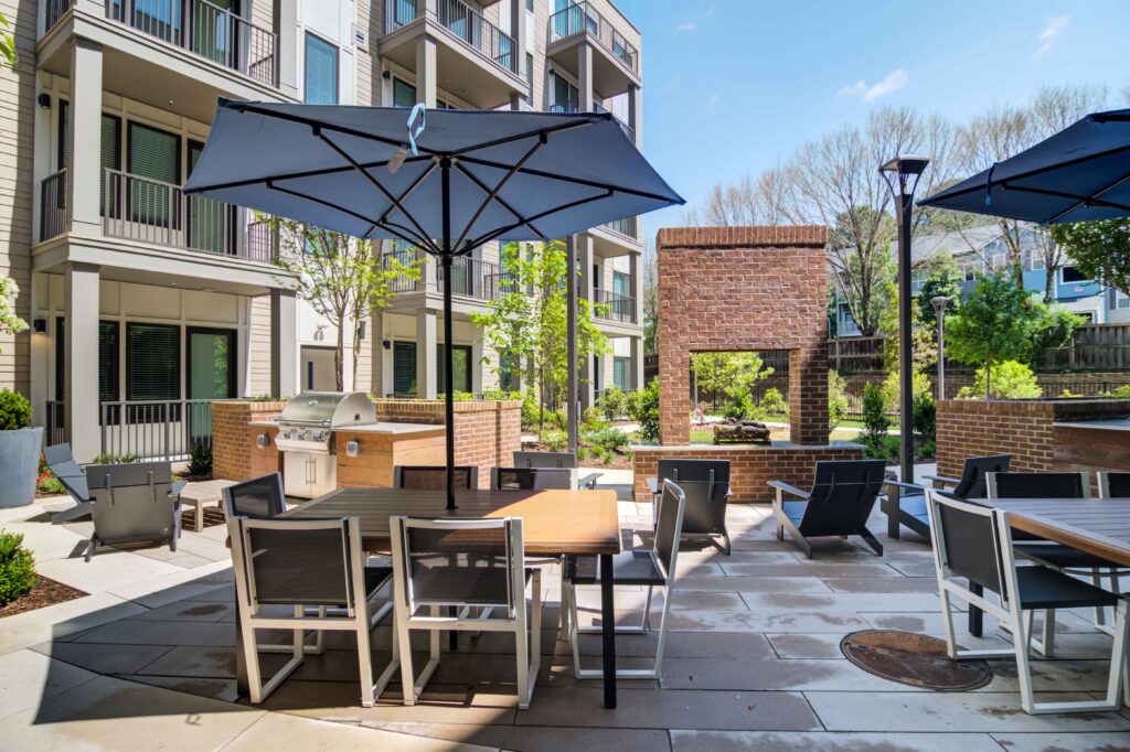 Outdoor patio area with tables and grill at Oleander