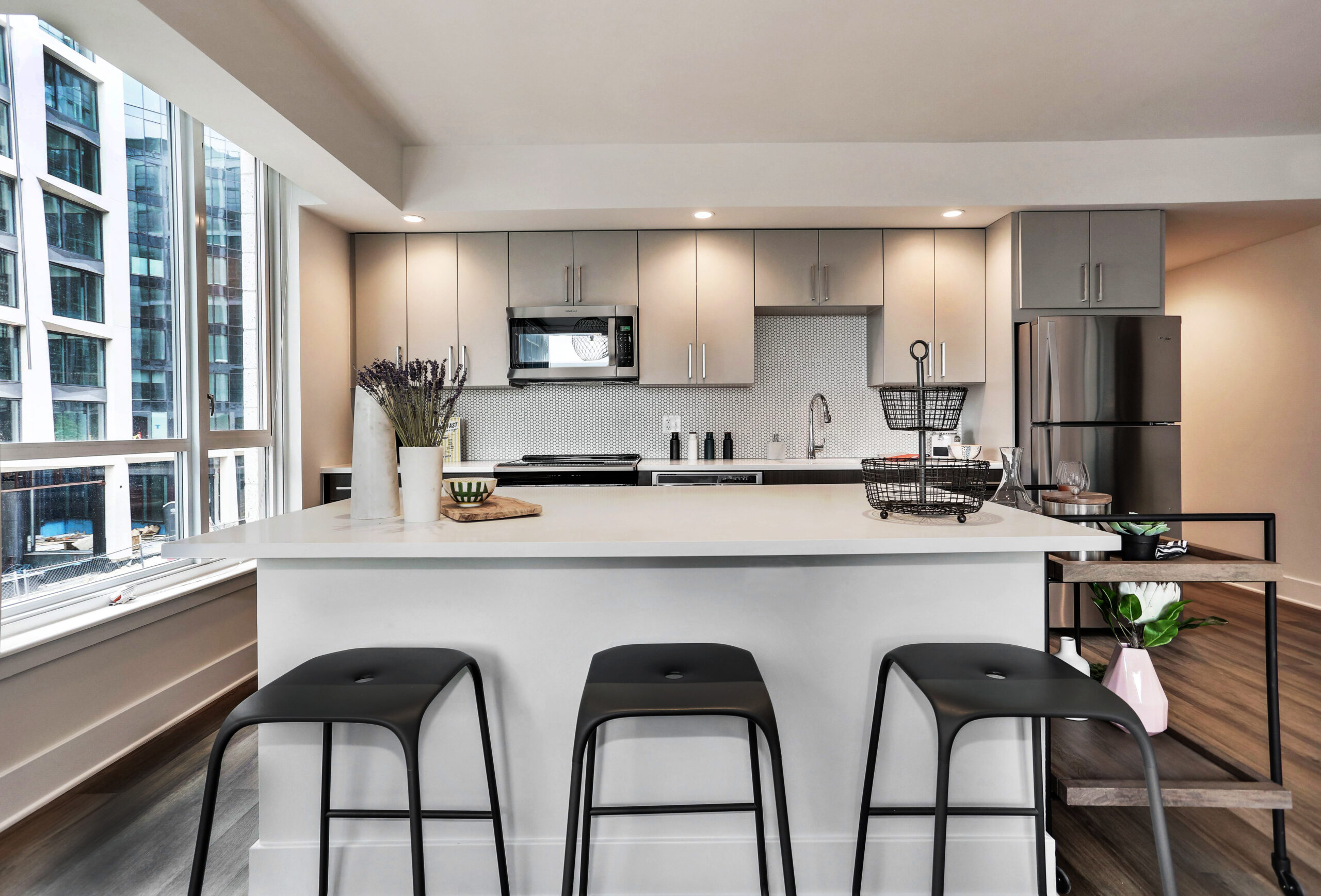 Model kitchen at Parc Riverside with tiled backsplash and kitchen island with bar seating