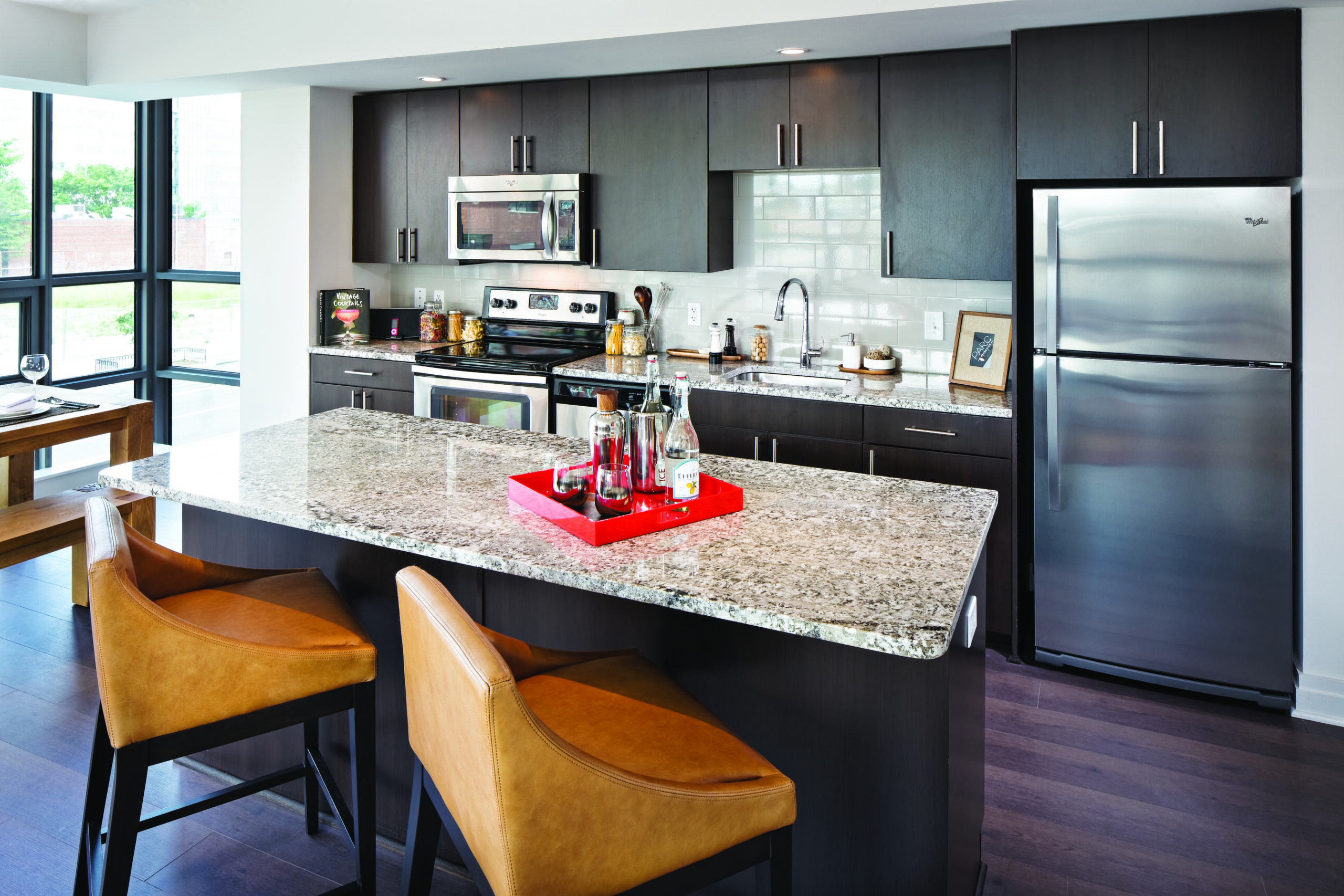 Model kitchen a Parc Riverside with stylish dark cabinets and kitchen island with seating