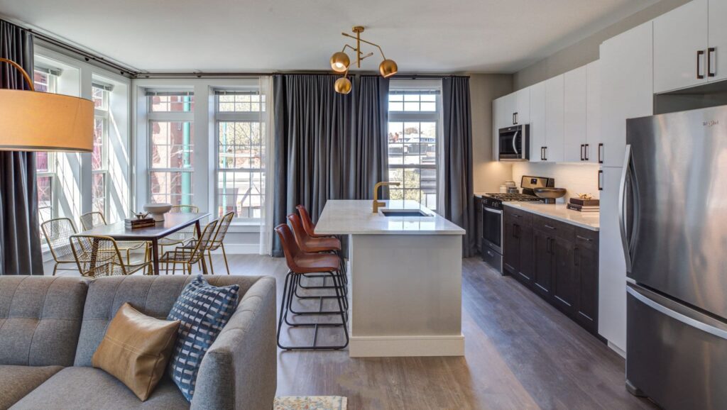 Couch, kitchen with island, and dining area at The Bradford