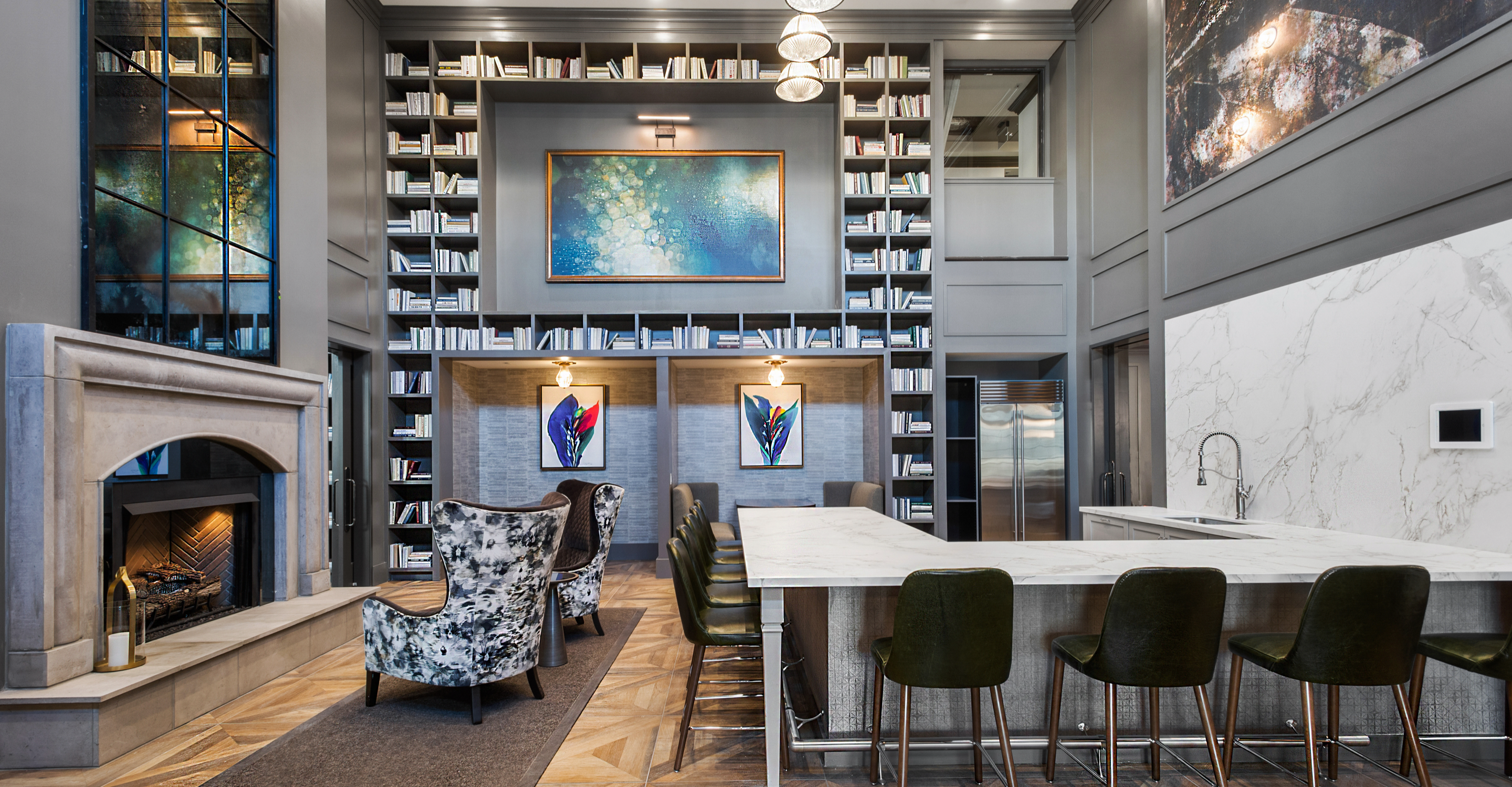 Seating around bar, high back armchairs by fireplace and tall bookcase in the background