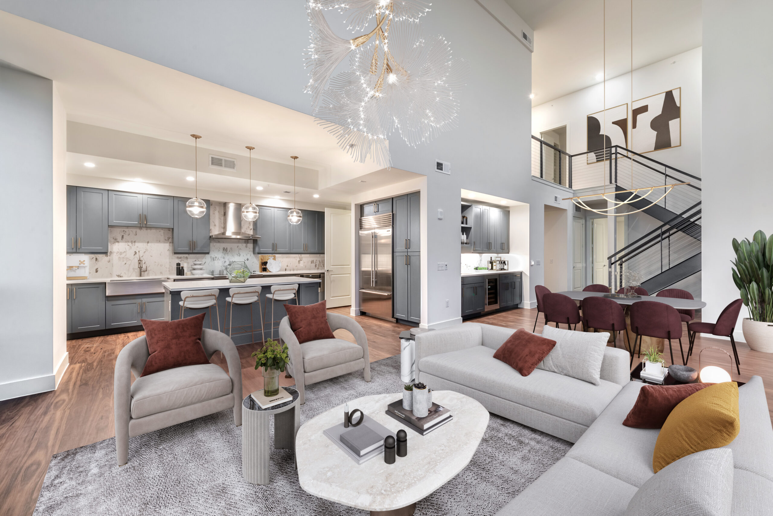 View of modern dark gray kitchen and two story staircase through the open living area at Aster's penthouse