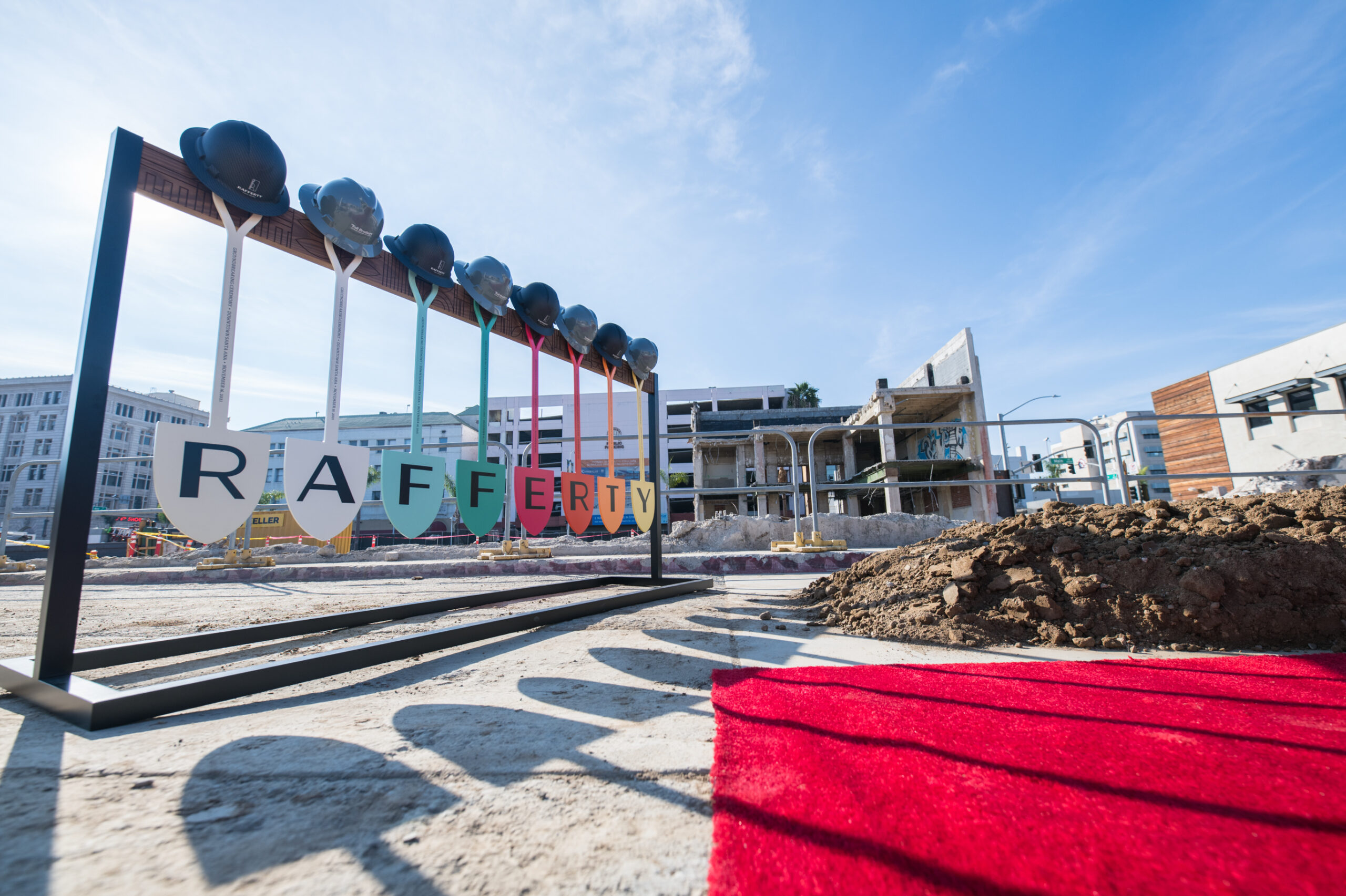 Colorful shovels hanging from a stand with a letter on each, spelling RAFFERTY, the name of a new multifamily community